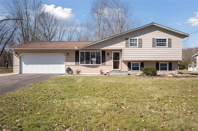 split level home with a front lawn, an attached garage, and driveway