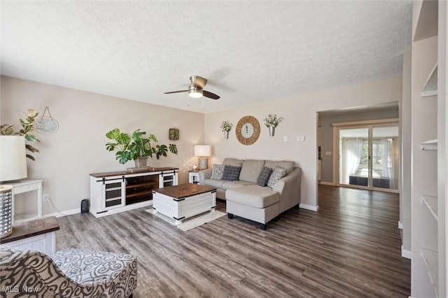 living room with baseboards, a textured ceiling, and wood finished floors