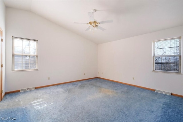 carpeted empty room featuring visible vents, ceiling fan, baseboards, and lofted ceiling