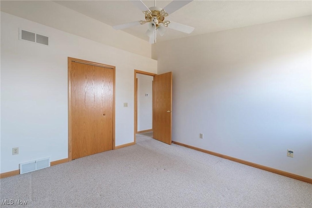 unfurnished bedroom featuring light colored carpet, visible vents, a closet, and baseboards