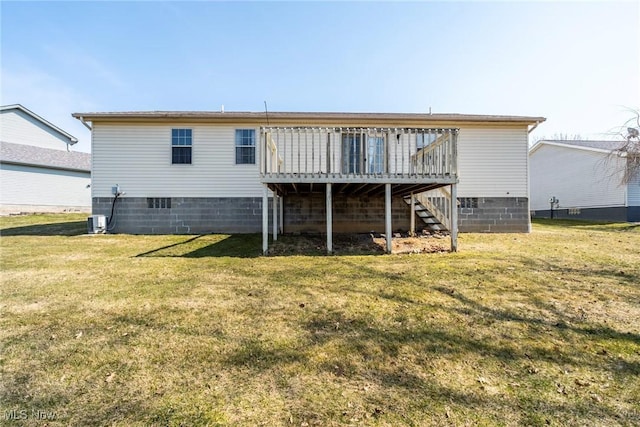 rear view of property with stairs, a deck, and a yard