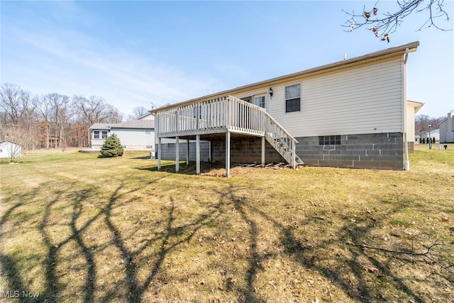 back of house featuring a yard, a wooden deck, and stairs