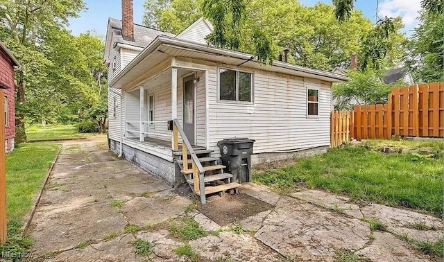 exterior space featuring a chimney and fence