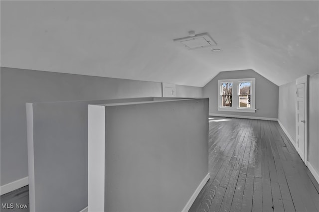 bonus room with vaulted ceiling, baseboards, and dark wood-type flooring