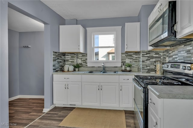 kitchen with a sink, dark wood finished floors, appliances with stainless steel finishes, light countertops, and baseboards