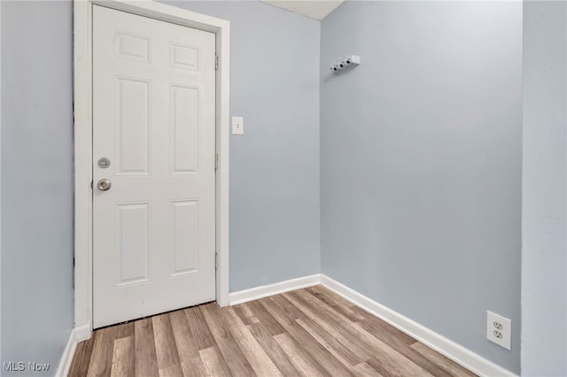 doorway to outside with baseboards and light wood-style flooring