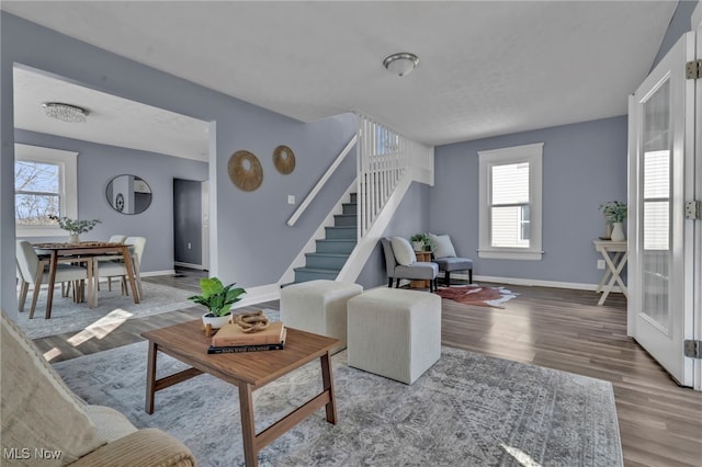 living room featuring stairway, wood finished floors, and baseboards