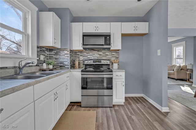 kitchen with plenty of natural light, backsplash, appliances with stainless steel finishes, and a sink