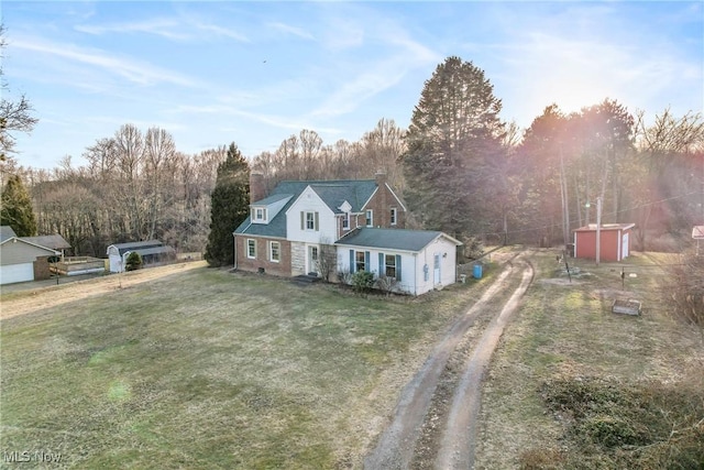 view of front of home featuring a front yard, an outdoor structure, and driveway