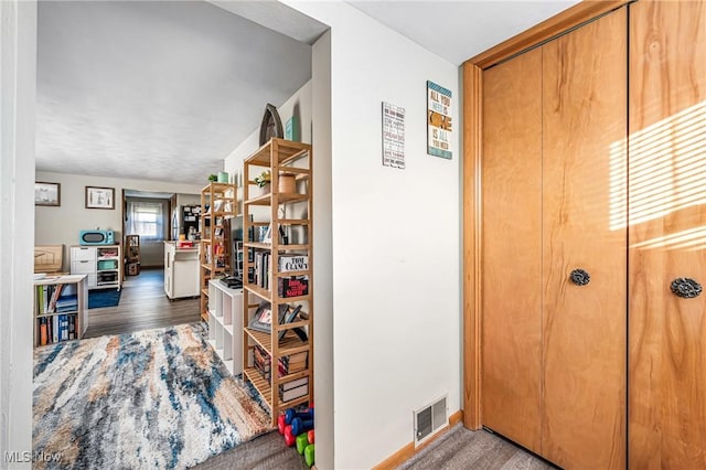 hallway featuring visible vents and wood finished floors