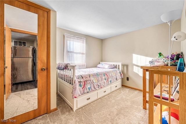 carpeted bedroom featuring baseboards and freestanding refrigerator