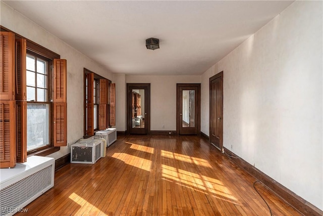 foyer entrance featuring hardwood / wood-style floors, radiator heating unit, and baseboards