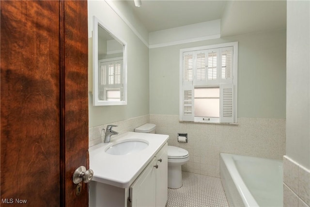 full bathroom featuring a wealth of natural light, a bathing tub, tile walls, and vanity