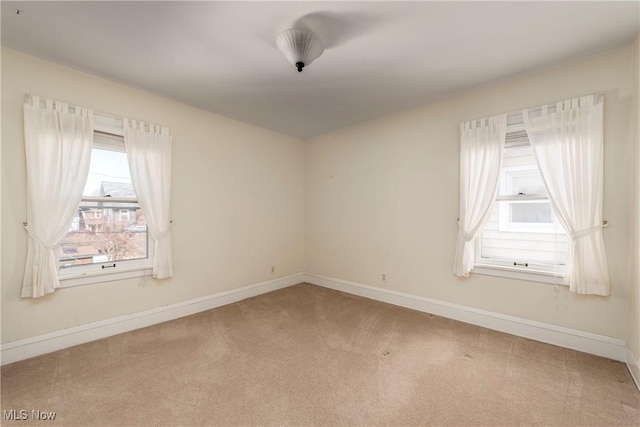 carpeted spare room featuring baseboards