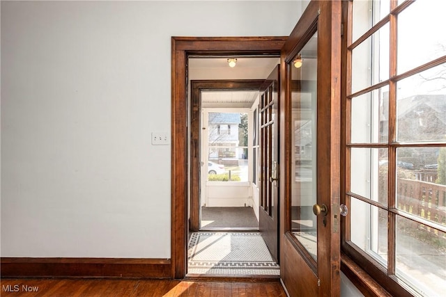 doorway featuring dark wood-style floors, baseboards, and french doors