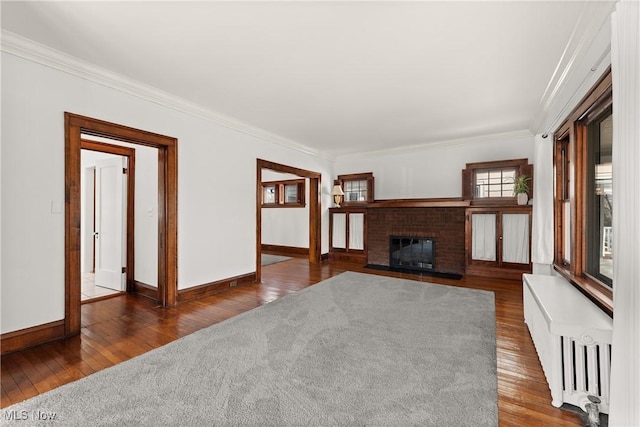 unfurnished living room featuring wood-type flooring, radiator heating unit, and crown molding