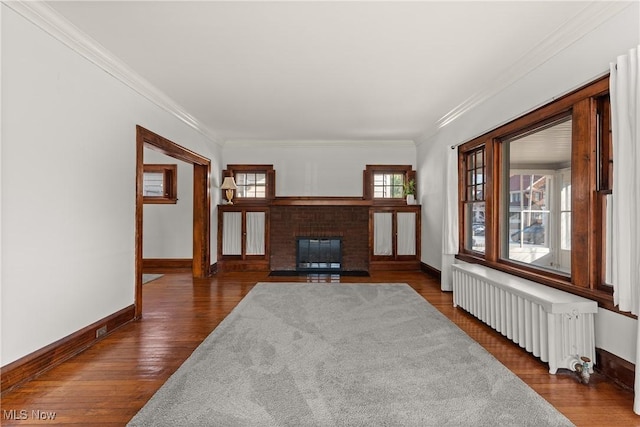 living area featuring ornamental molding, dark wood finished floors, radiator heating unit, a fireplace, and baseboards