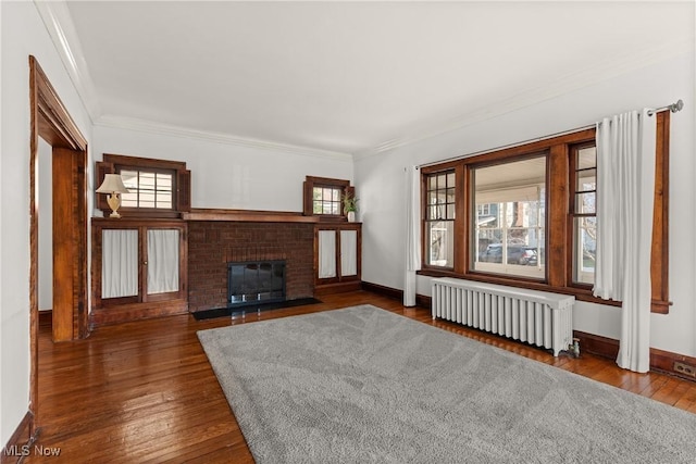 unfurnished living room featuring ornamental molding, radiator, and hardwood / wood-style floors