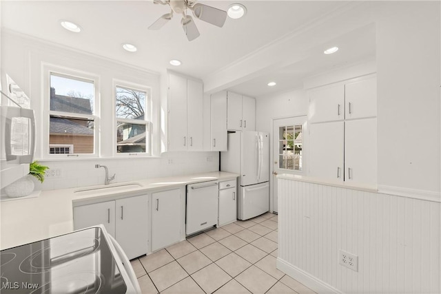 kitchen with white cabinetry, white appliances, light countertops, and a sink