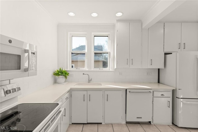 kitchen featuring white appliances, light tile patterned floors, light countertops, and a sink