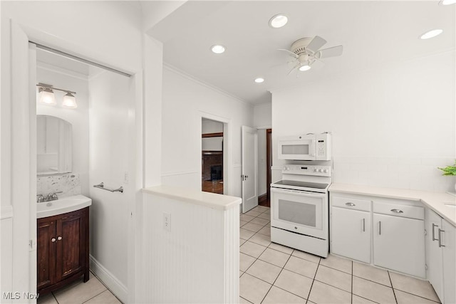 kitchen with a sink, backsplash, white appliances, crown molding, and light countertops