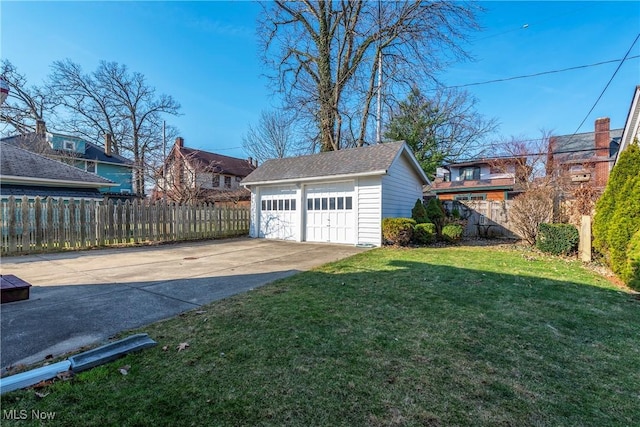 view of yard with a detached garage, an outdoor structure, and fence