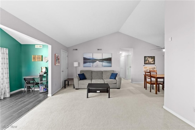 living area featuring lofted ceiling, baseboards, and visible vents