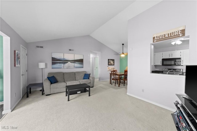 living area with visible vents, lofted ceiling, light colored carpet, and ceiling fan