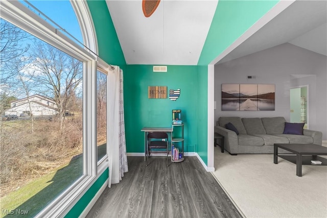 interior space with visible vents, baseboards, wood finished floors, and vaulted ceiling