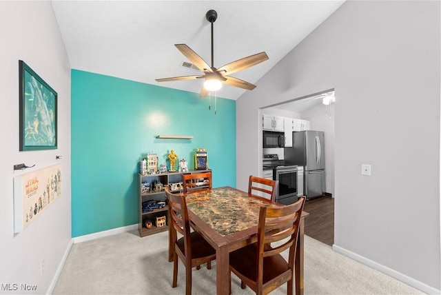 dining area featuring ceiling fan, vaulted ceiling, baseboards, and light carpet