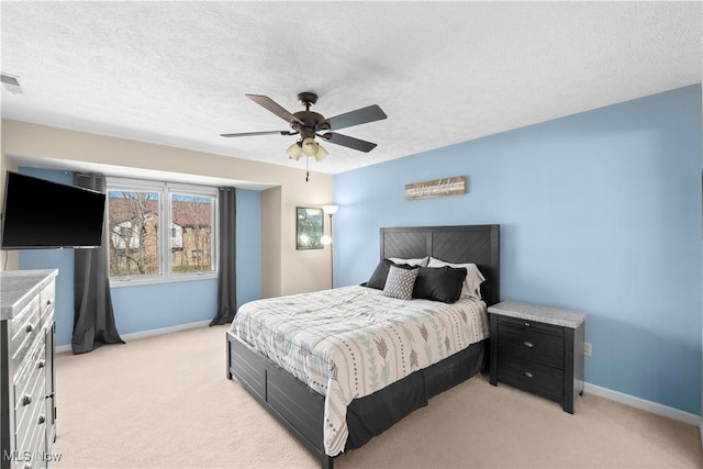 bedroom with light colored carpet, a textured ceiling, and baseboards