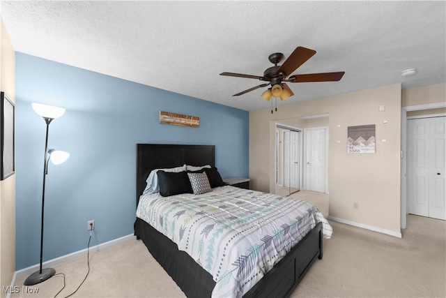 carpeted bedroom featuring a ceiling fan, baseboards, and a textured ceiling