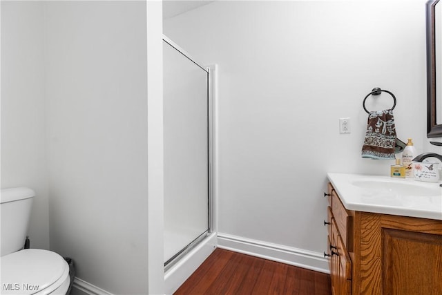 full bath with wood finished floors, toilet, a stall shower, and vanity