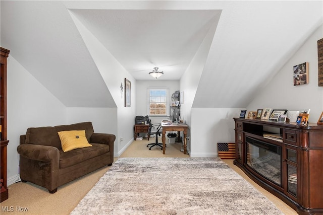 carpeted office space featuring baseboards and vaulted ceiling