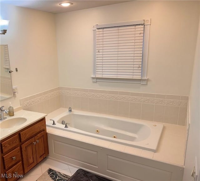bathroom with tile patterned flooring, vanity, and a tub with jets