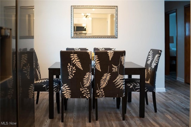 dining space with baseboards and wood finished floors