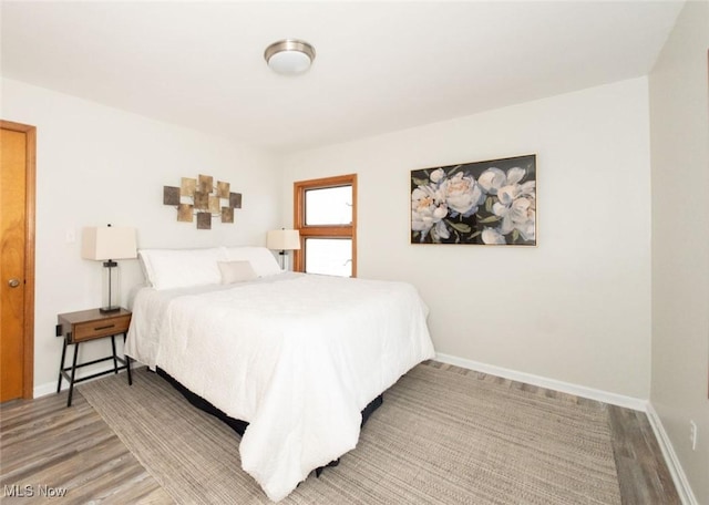 bedroom with baseboards and wood finished floors