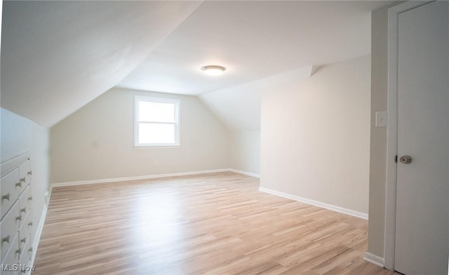 bonus room featuring baseboards, lofted ceiling, and light wood-style floors