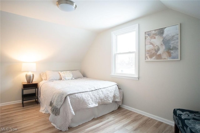 bedroom featuring vaulted ceiling, baseboards, and wood finished floors