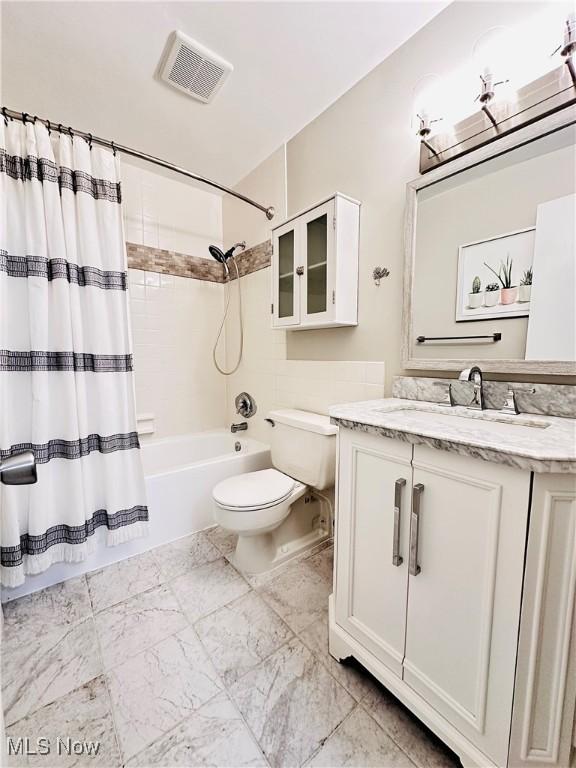 full bathroom with visible vents, vanity, toilet, and shower / tub combo