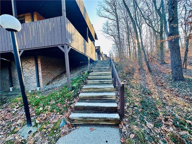 view of side of property with brick siding and stairs