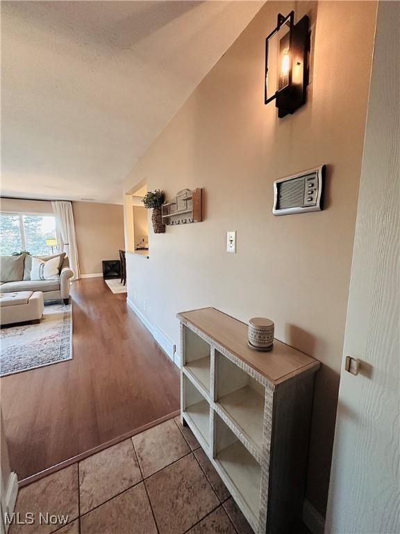 hallway with tile patterned flooring and baseboards