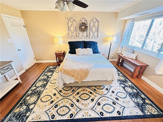 bedroom featuring visible vents, wood finished floors, baseboards, and a textured ceiling