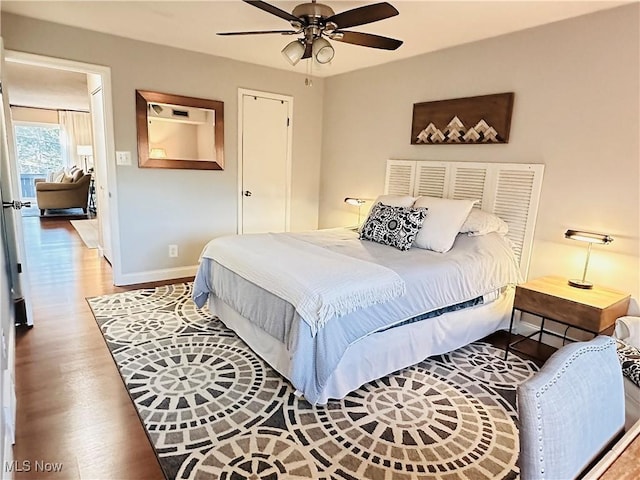 bedroom with baseboards, wood finished floors, and a ceiling fan