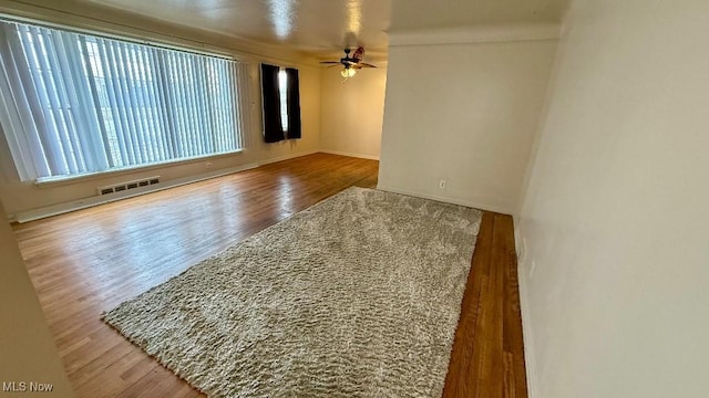 spare room featuring wood finished floors, visible vents, and ceiling fan