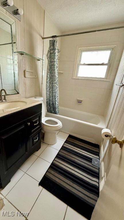 full bath with toilet, shower / tub combo with curtain, tile patterned floors, a textured ceiling, and vanity