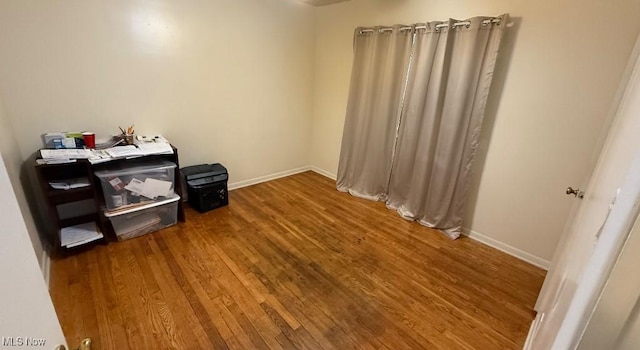 interior space with baseboards and wood finished floors