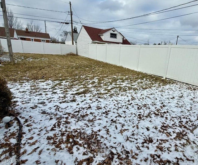 yard layered in snow featuring fence