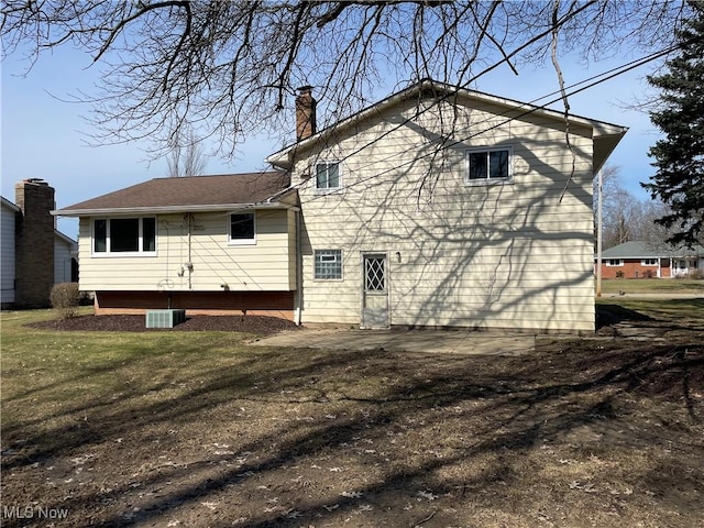 rear view of property with a lawn and a chimney