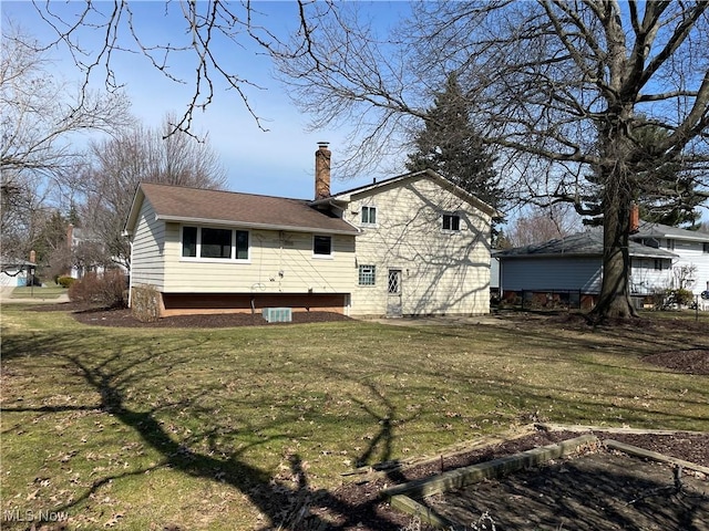 rear view of property with a lawn and a chimney